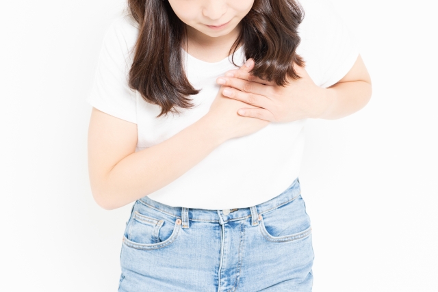 胸を抱える女性